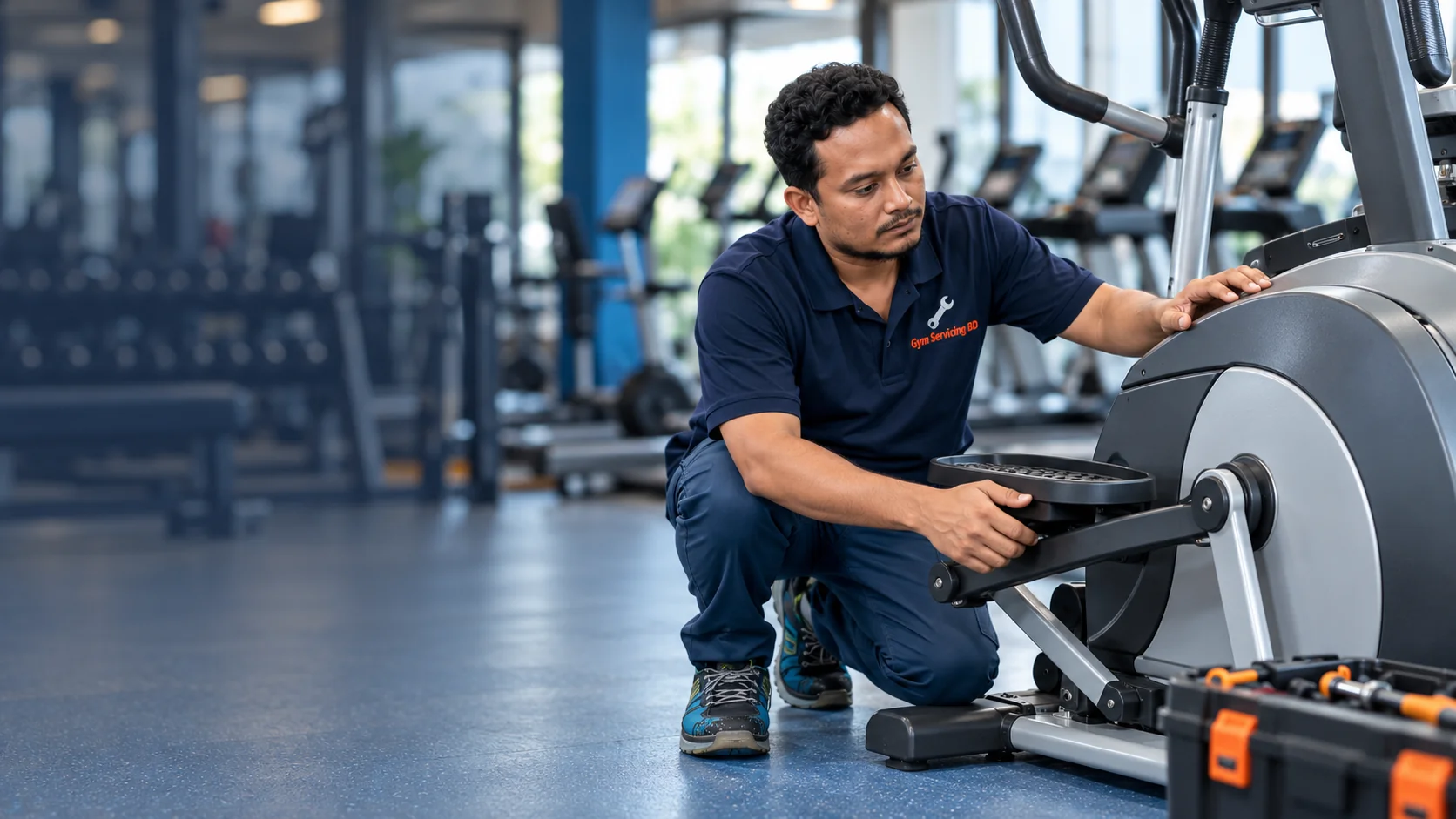 Technician inspecting the stationary pedal linkage of an elliptical cross trainer
